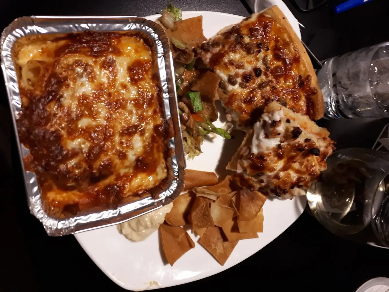Baked lasagna served with pizza slices and pita crisps at DJ's Pizzeria & Lounge in St. Albert, AB