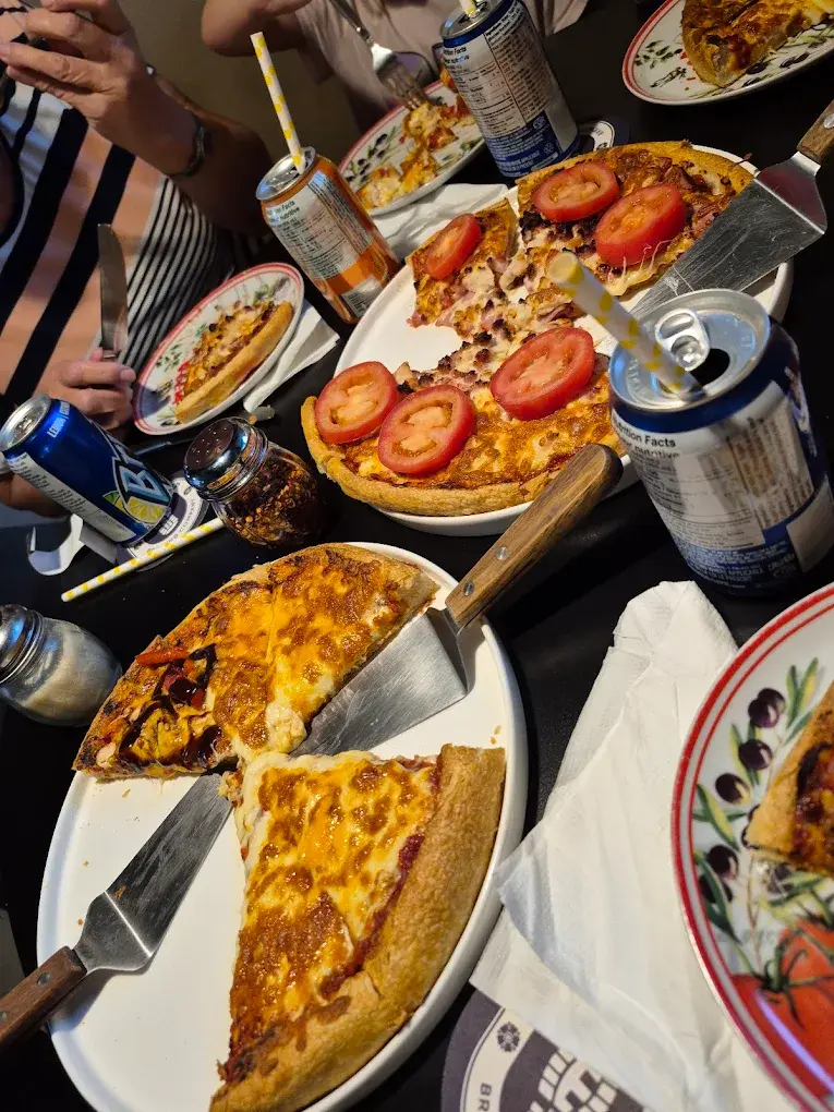 Family pizza night - a table of shared pizzas and drinks at DJ's Pizzeria & Lounge in St. Albert, AB